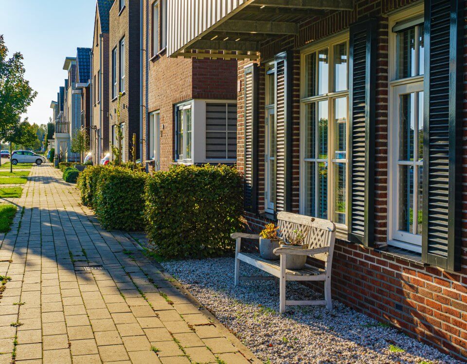 Front view of an apartment building with front patios and basic landscaping.