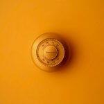 Old-school thermostat with an orange hue over the image.