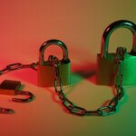 Three different size pad locks with a chain going through them on a red and green background.