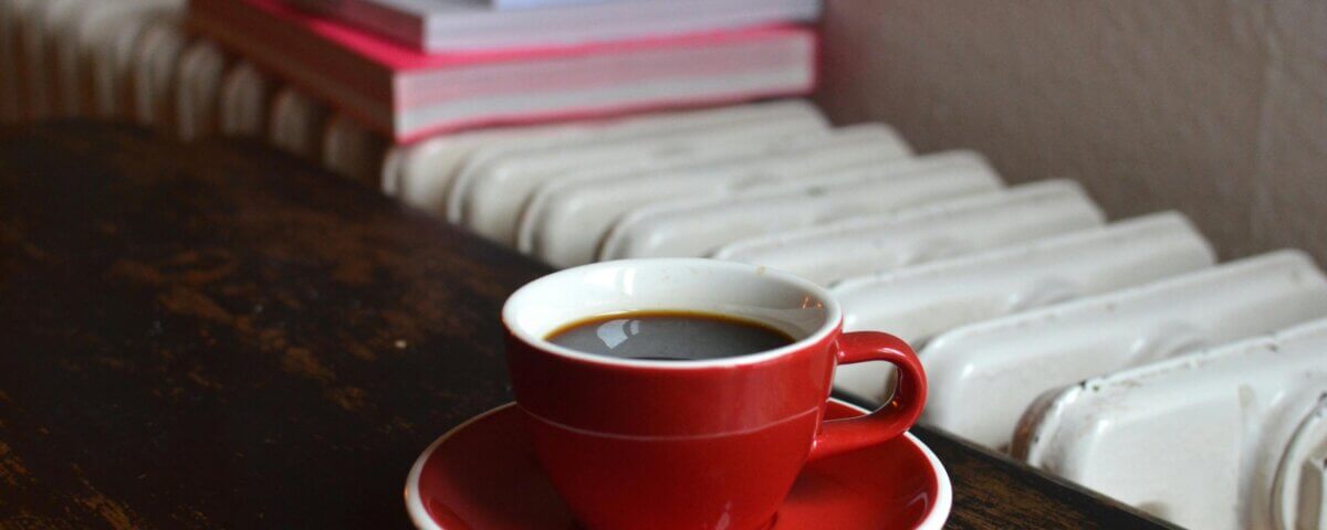 Cup of coffee near a heater supported by a heat pump system.