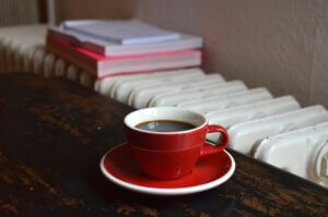 Cup of coffee near a heater supported by a heat pump system.