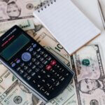 Calculator, paper, and money—paying energy bills.