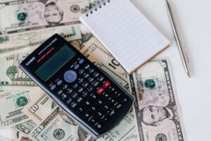 Calculator, paper, and money—paying energy bills.